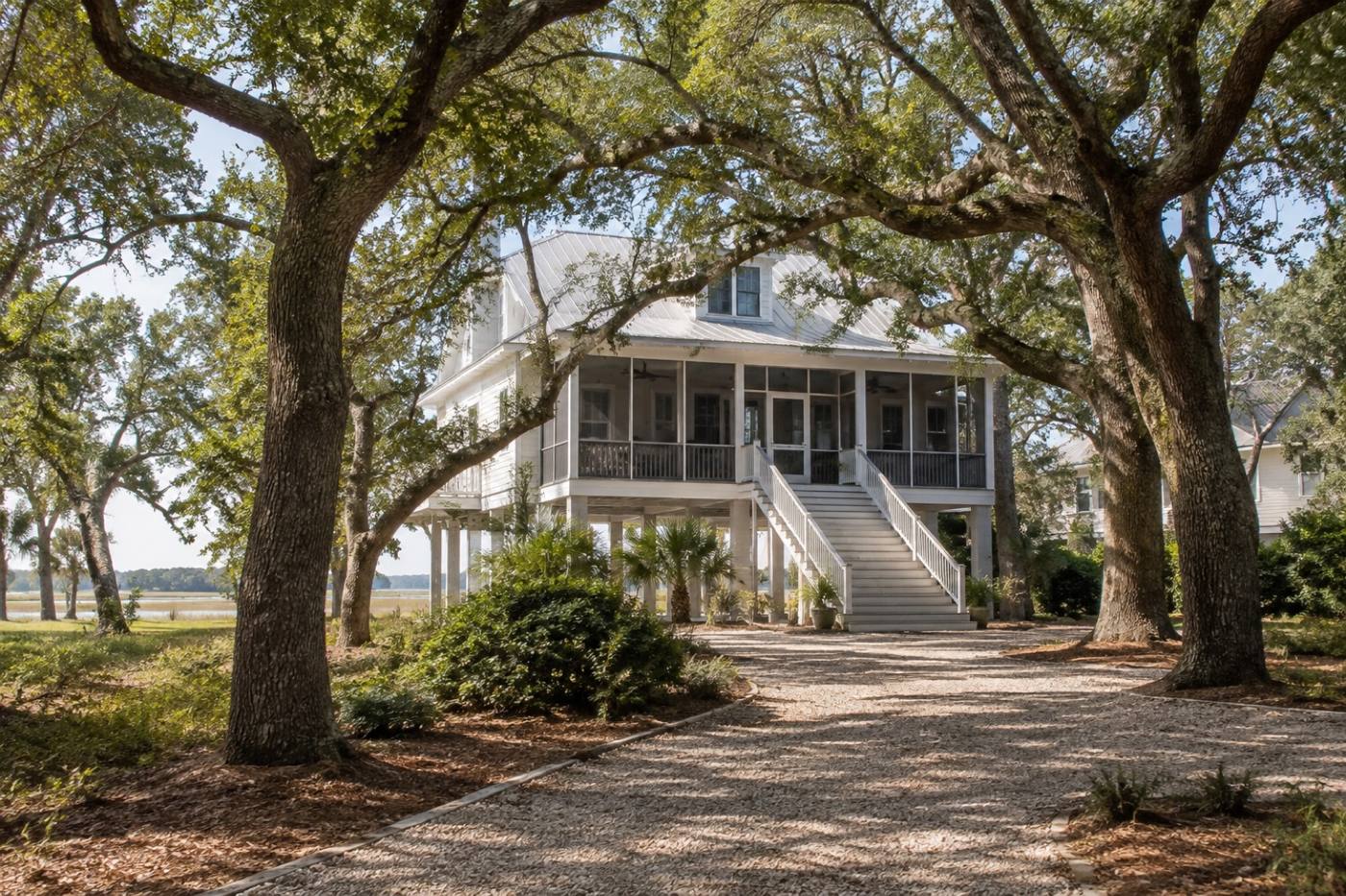 A raised coastal cottage with a screened porch among live oaks