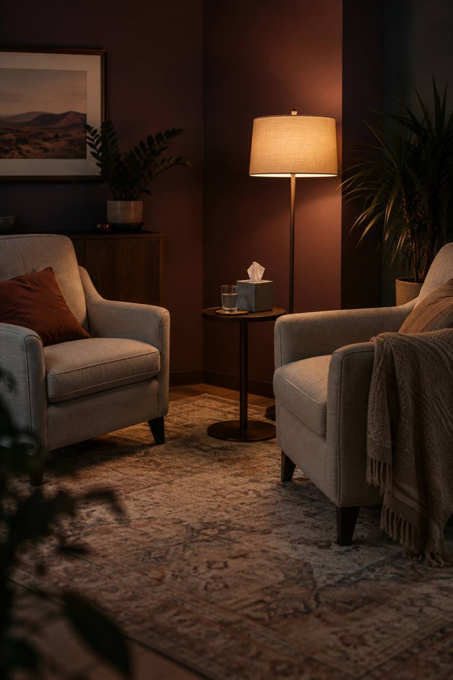 A small counseling room with two armchairs and a floor lamp