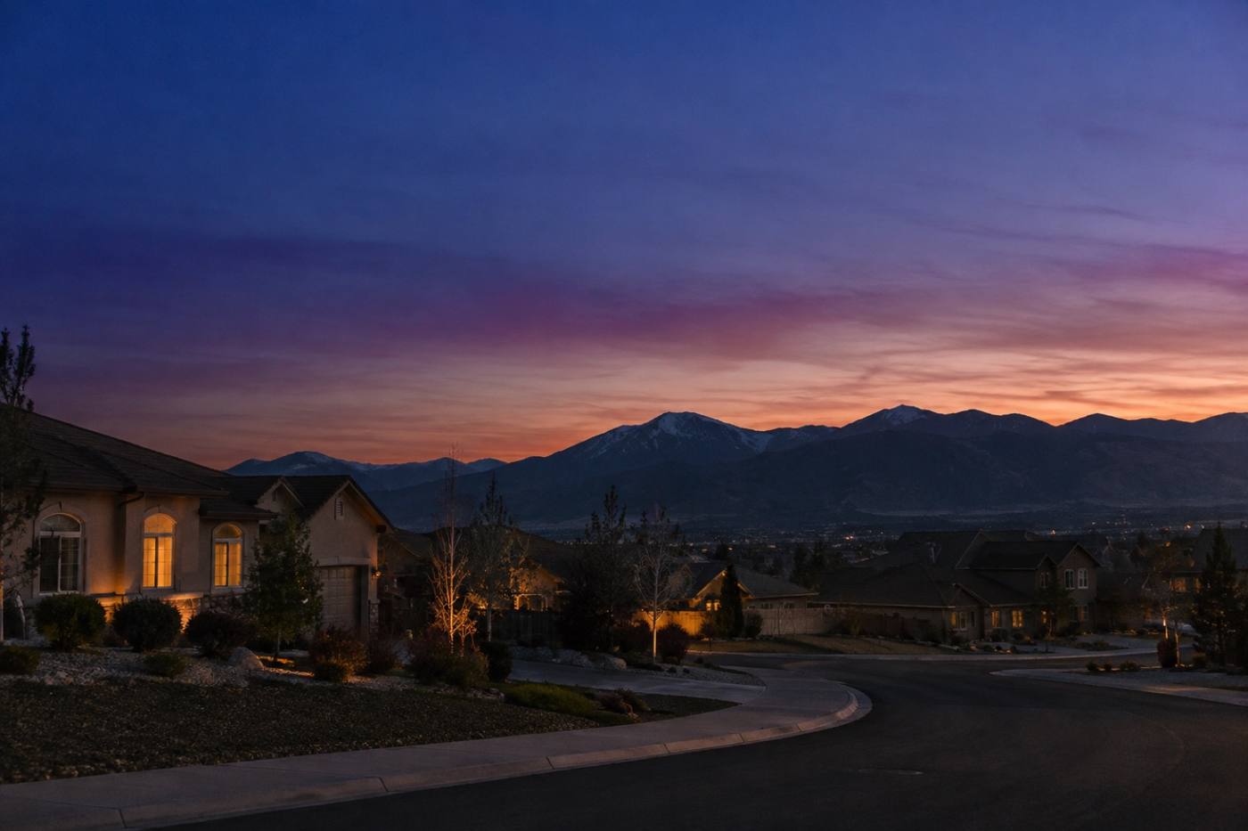 Reno neighborhood at dusk with the Sierra Nevada foothills behind it